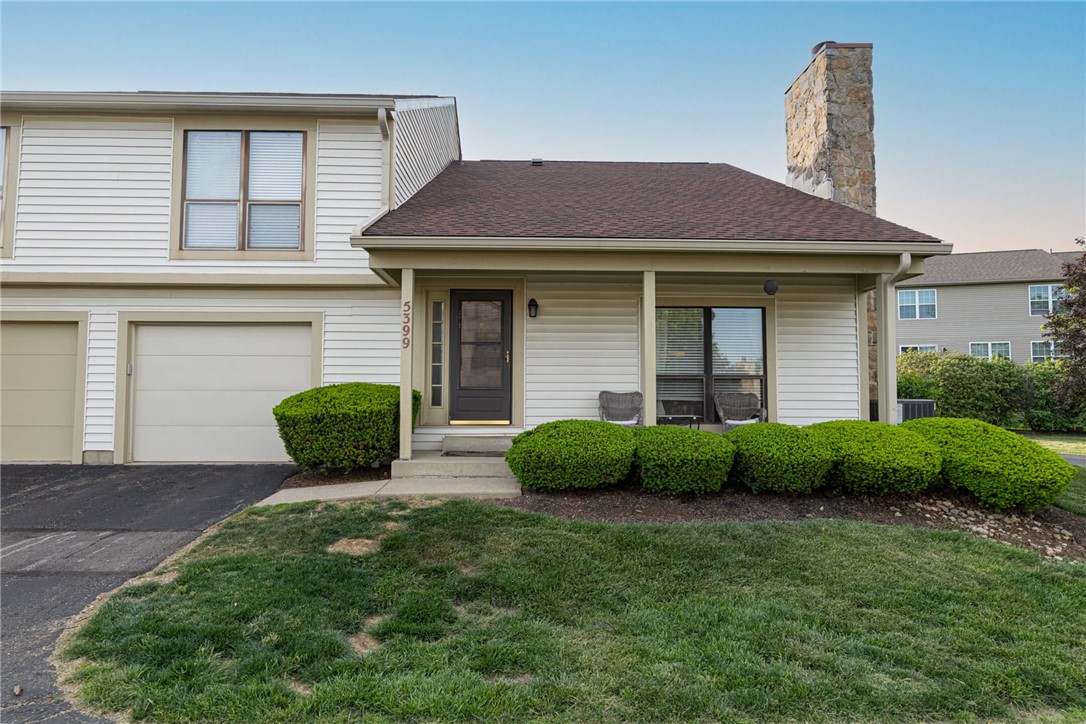 This charming home offers a welcoming facade with a cozy front porch and attached garage.