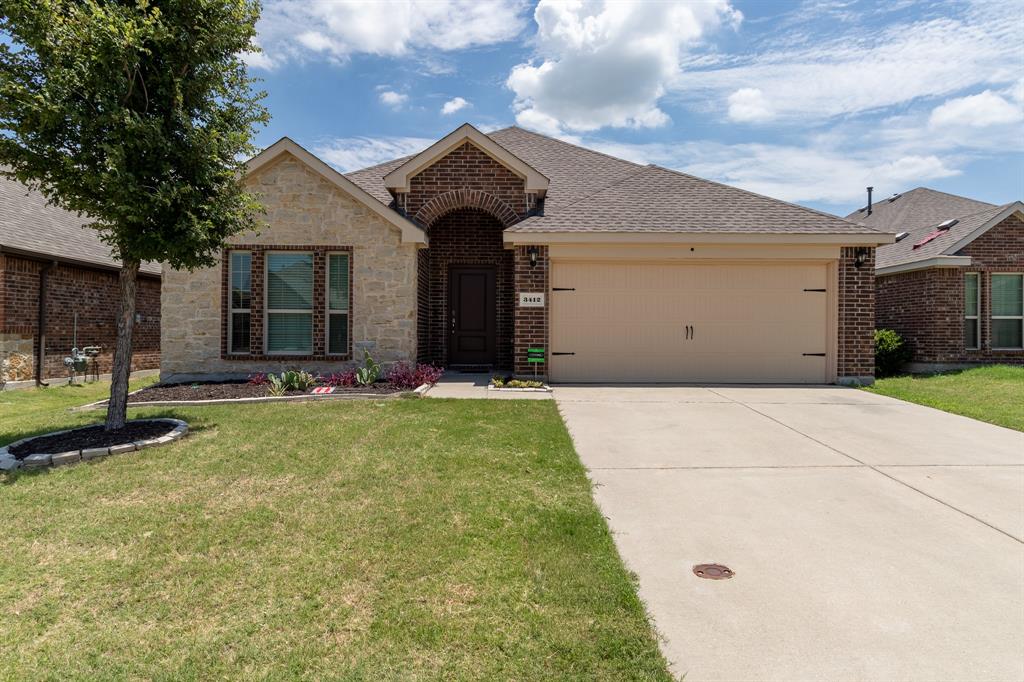 3412 Rio Grande Road Little Elm, TX 75068 - Photo 2 of 2 Stone and brick exterior with a prominent arched entry, attached two-car garage, and a concrete driveway