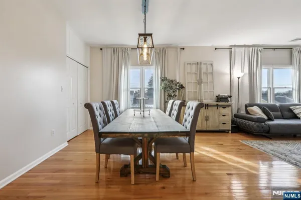 a view of a a dining room with furniture window and wooden floor