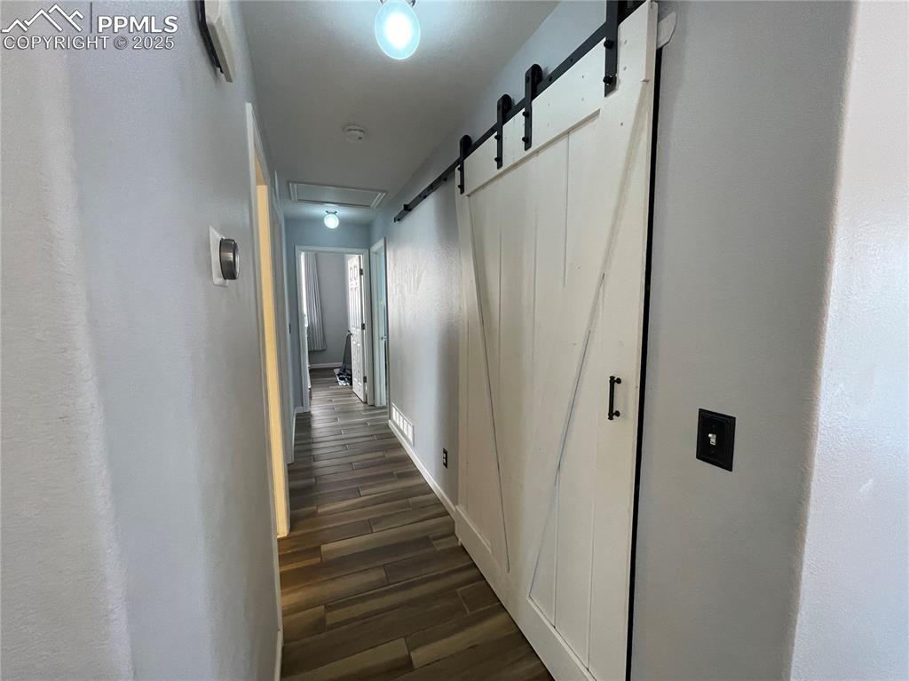 7631 Coffee Road Peyton, CO 80831 - Photo 12 of 28 a view of a hallway with wooden floor and staircase