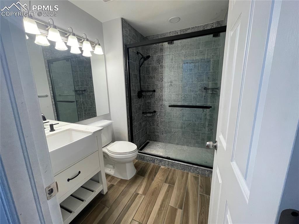 7631 Coffee Road Peyton, CO 80831 - Photo 15 of 28 a bathroom with a toilet shower and a mirror