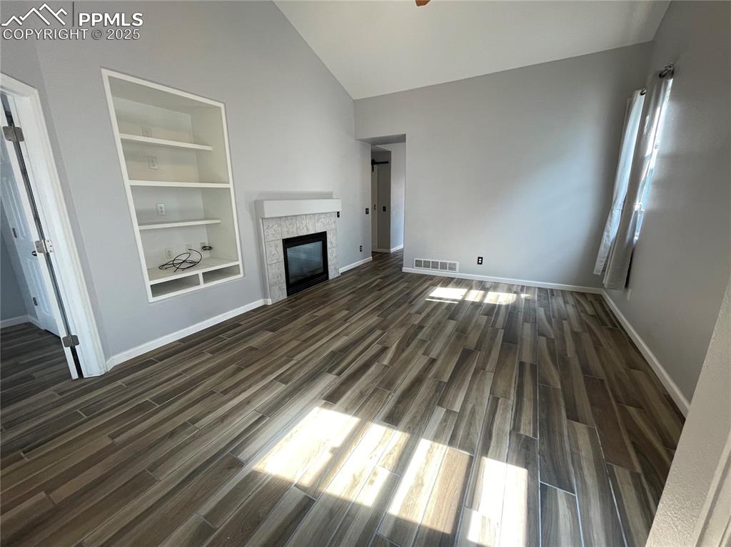 7631 Coffee Road Peyton, CO 80831 - Photo 2 of 28 a view of an empty room wooden floor and a window