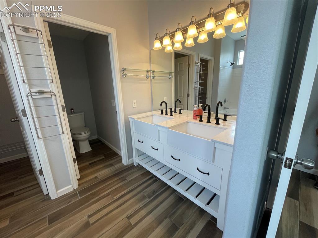 7631 Coffee Road Peyton, CO 80831 - Photo 22 of 28 a bathroom with a double vanity sink and a mirror