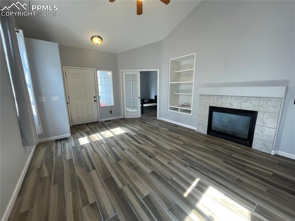 7631 Coffee Road Peyton, CO 80831 - Photo 4 of 28 wooden floor in an empty room with a fireplace
