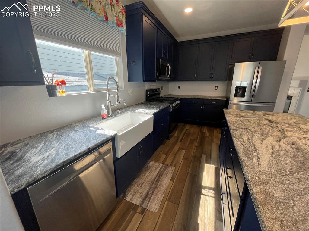 7631 Coffee Road Peyton, CO 80831 - Photo 10 of 28 a kitchen with granite countertop stainless steel appliances a sink stove top oven and granite counter tops