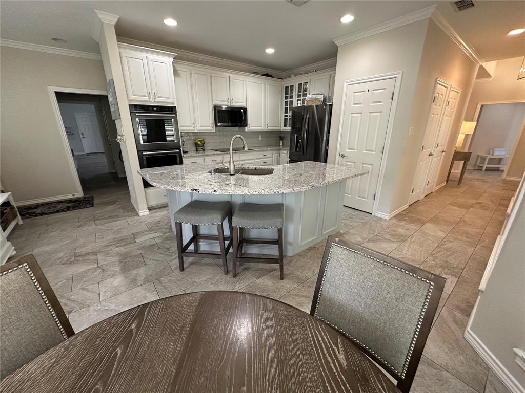 1425 Pecan Hill Road Stephenville, TX 76401 - Photo 16 of 40 a living room with stainless steel appliances furniture a rug and a kitchen view