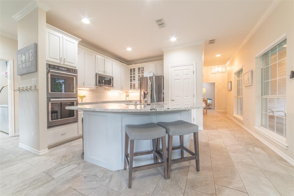 1425 Pecan Hill Road Stephenville, TX 76401 - Photo 36 of 40 a kitchen with kitchen island granite countertop wooden cabinets and counter space