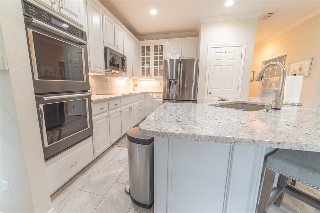 1425 Pecan Hill Road Stephenville, TX 76401 - Photo 6 of 40 a kitchen with stainless steel appliances granite countertop a sink stove and refrigerator