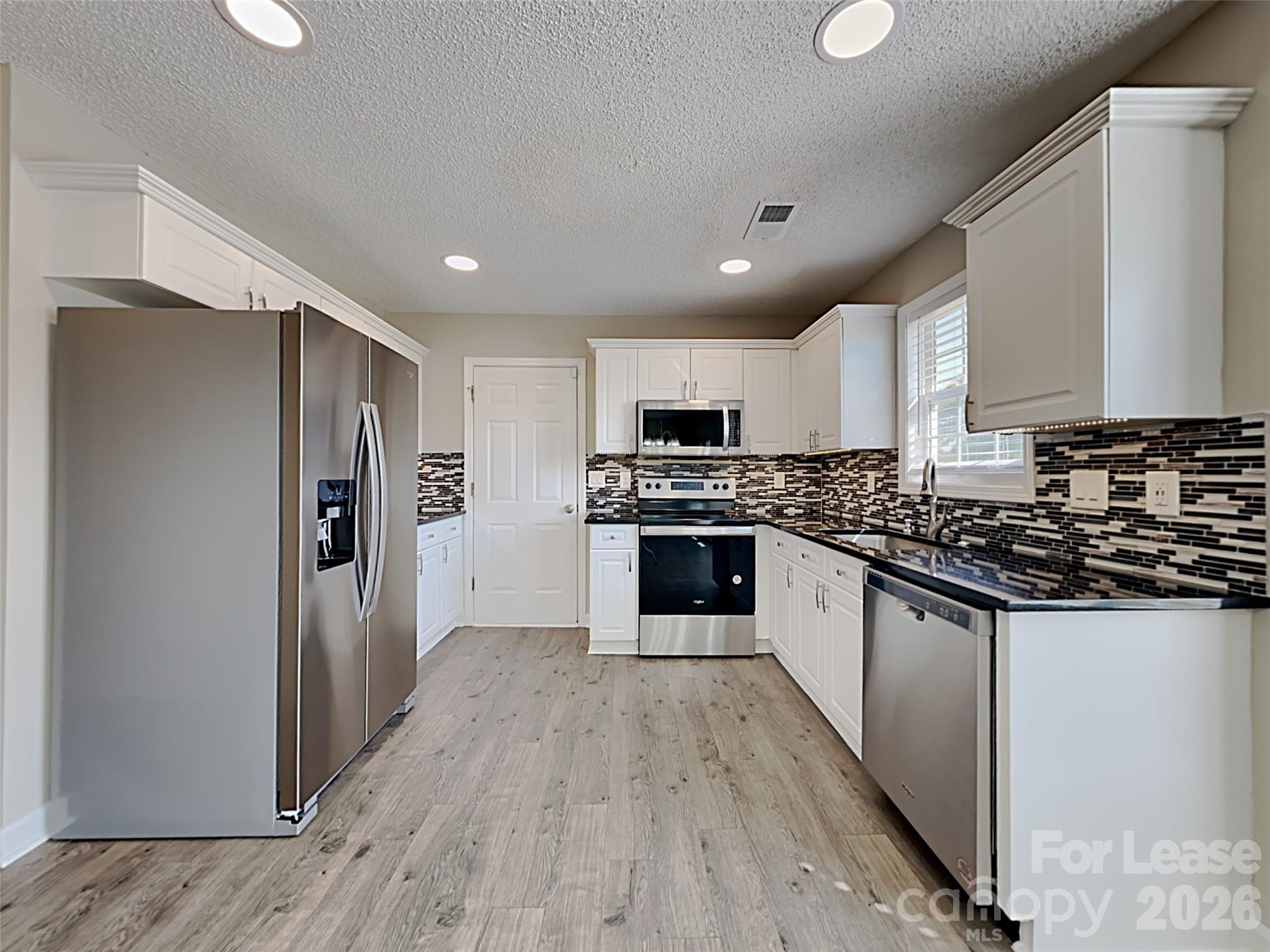 2006 Proverbs Court Monroe, NC 28110 - Photo 5 of 16 a large kitchen with stainless steel appliances granite countertop a stove a refrigerator and a sink