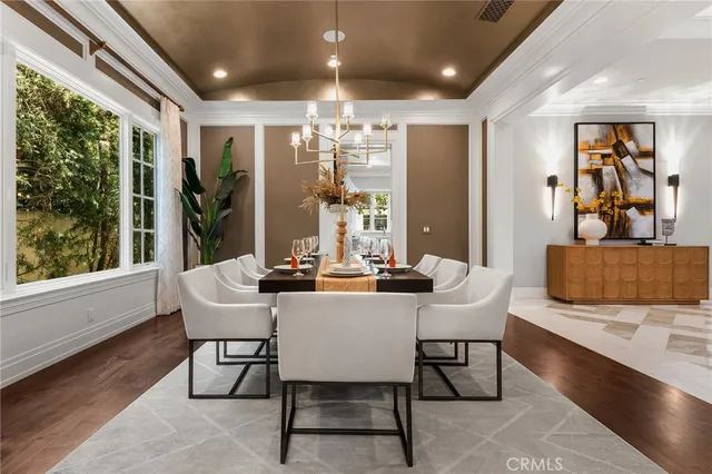a kitchen with a chandelier stainless steel appliances dining table and chair