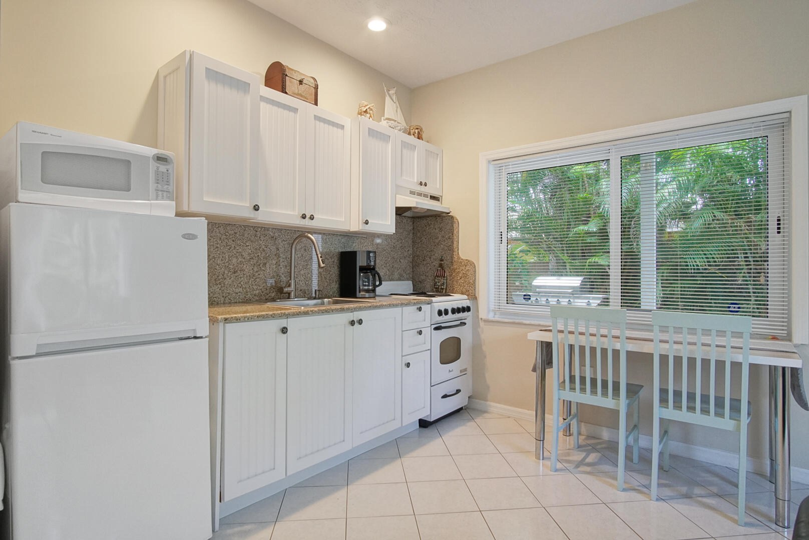 413 Hernando Street Fort Pierce, FL 34949 - Photo 28 of 43 a kitchen with white cabinets and white appliances