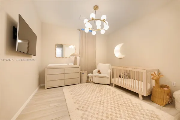 a bedroom with a bed and a chandelier