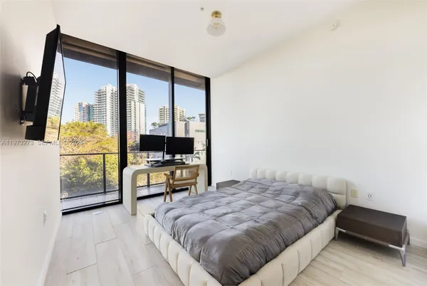 a bedroom with a bed and large window