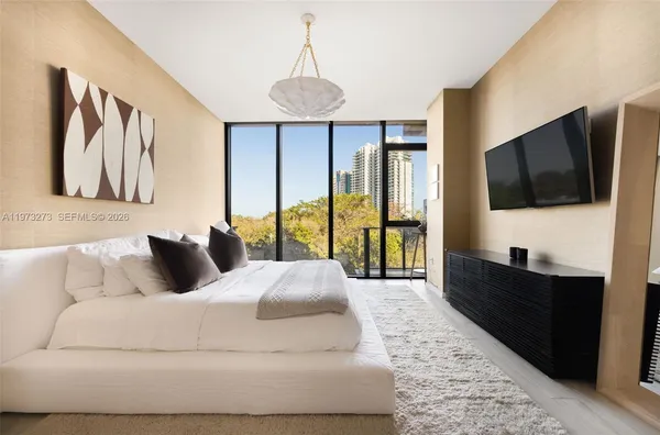 a bedroom with a large bed and a flat screen tv