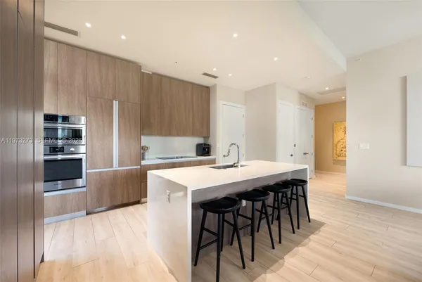 a kitchen with kitchen island a dining table and chairs