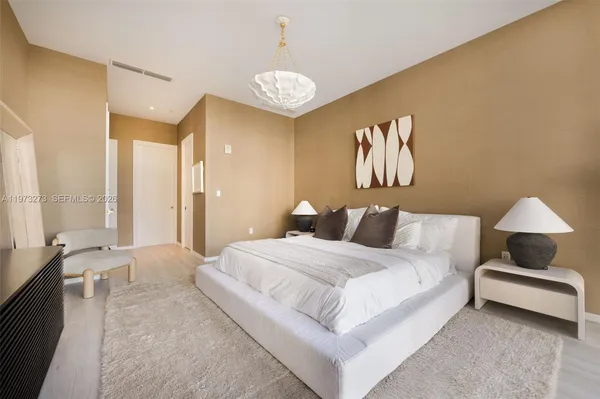 a bedroom with a bed and a chandelier