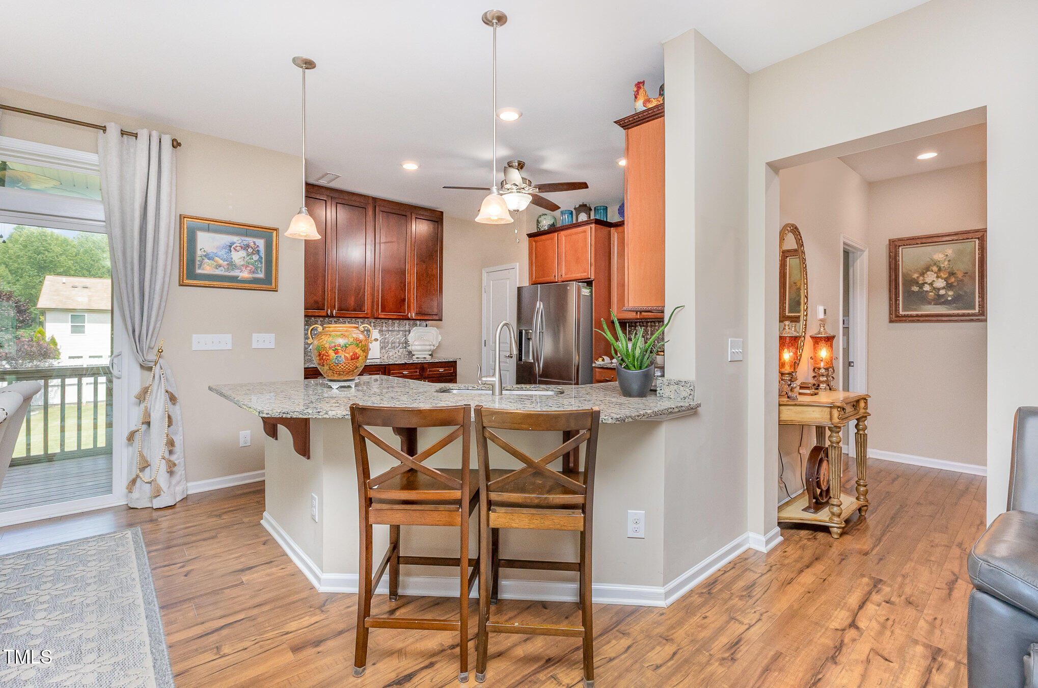 1205 Barnford Mill Road Wake Forest, NC 27587 - Photo 5 of 17 a open kitchen with stainless steel appliances granite countertop a stove top oven a refrigerator a dining table and chairs with wooden floor