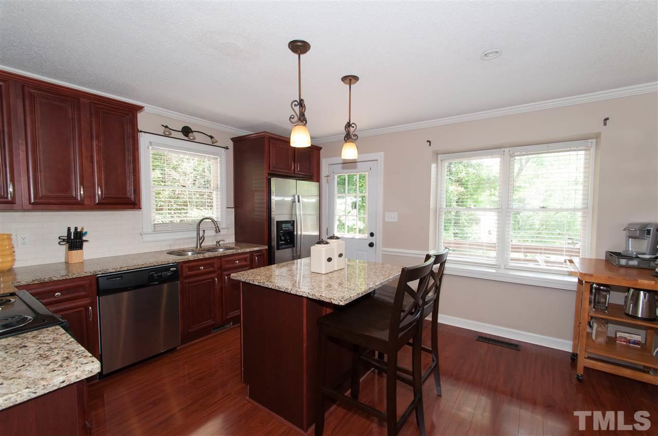 7304 Chicora Court Raleigh, NC 27615 - Photo 2 of 25 a kitchen with granite countertop a sink dining table and chairs