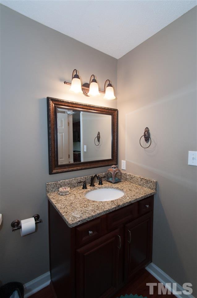 7304 Chicora Court Raleigh, NC 27615 - Photo 16 of 25 a bathroom with a granite countertop sink and a mirror