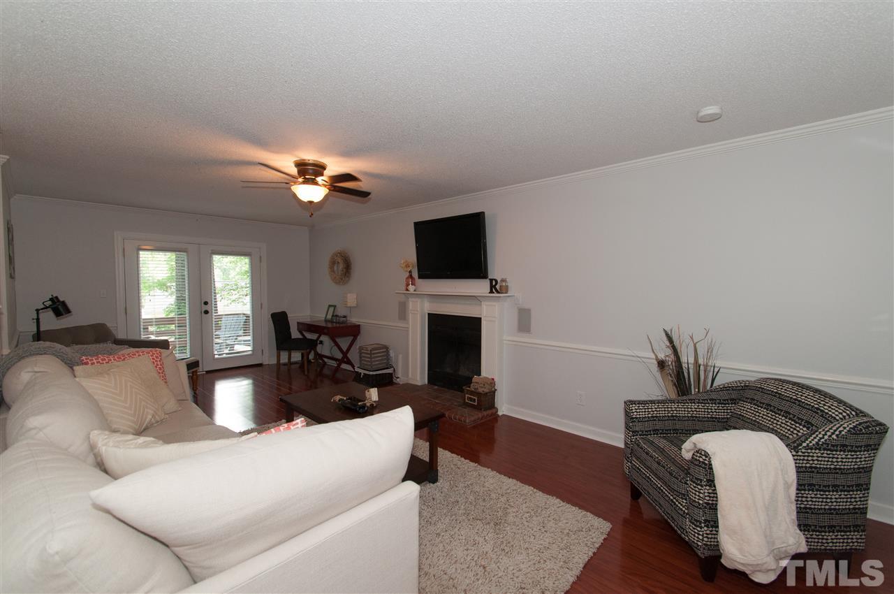 7304 Chicora Court Raleigh, NC 27615 - Photo 8 of 25 a living room with furniture a fireplace and a flat screen tv