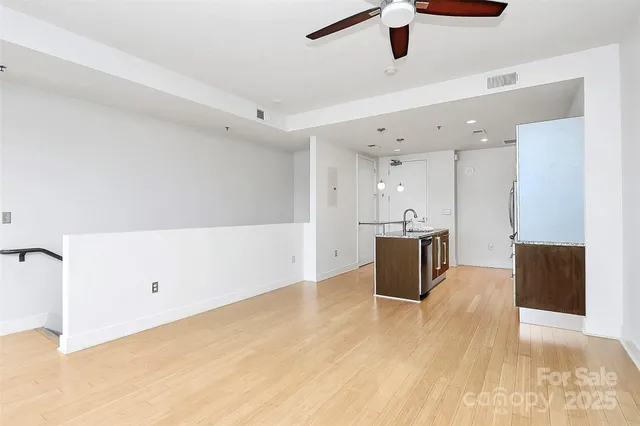 a view of a kitchen with kitchen island a sink dishwasher and a stove with wooden floor