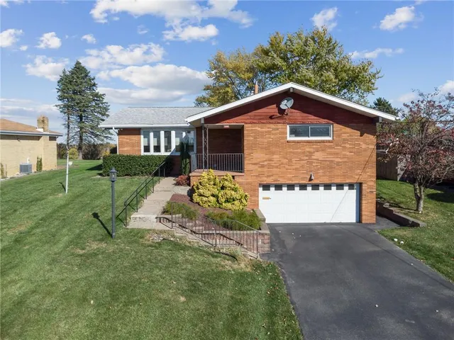 a view of a house with a yard and fence