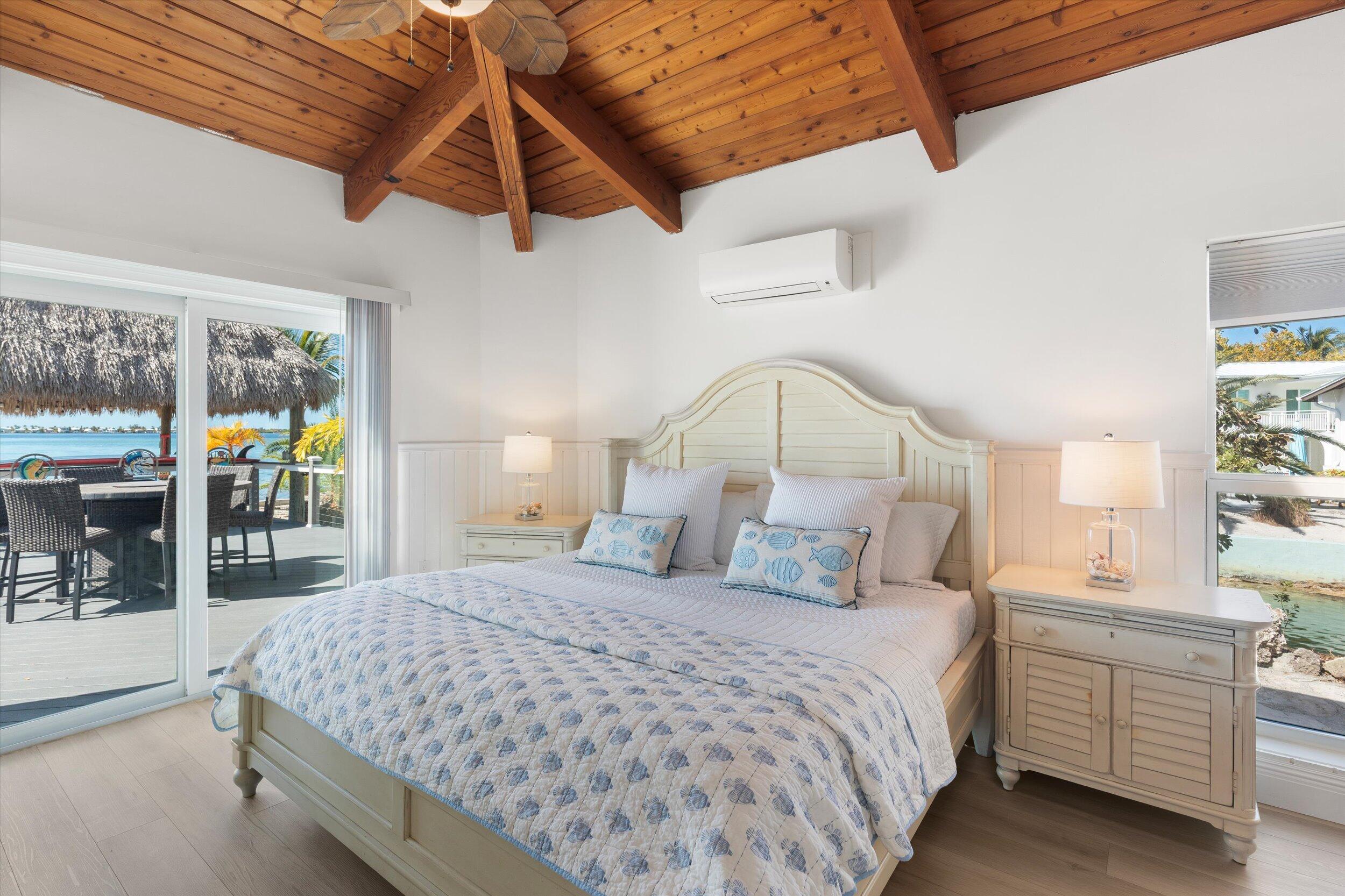 29581 Richard Road Big Pine Key, FL 33043 - Photo 29 of 78 a bedroom with a large bed and a chandelier