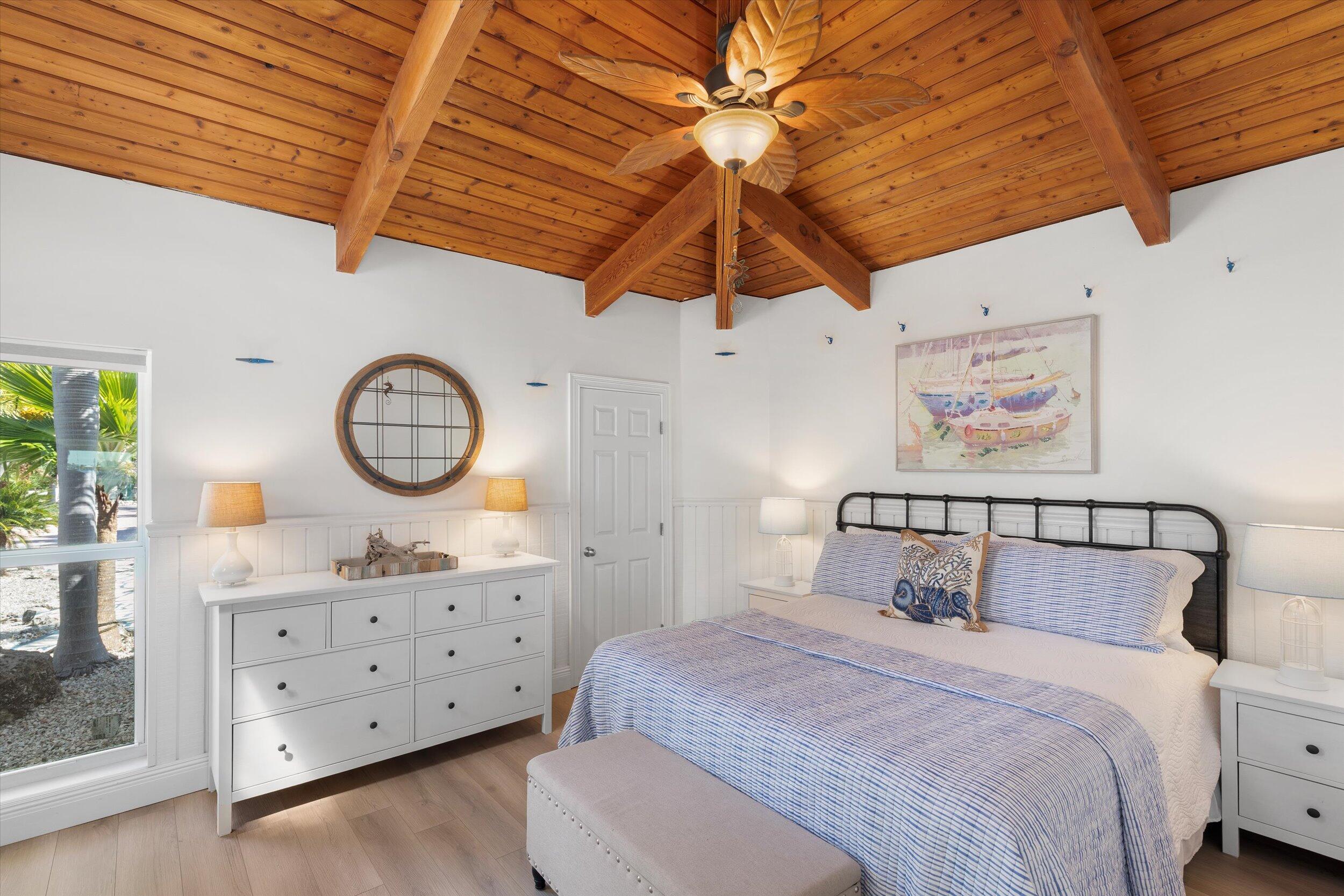 29581 Richard Road Big Pine Key, FL 33043 - Photo 37 of 78 a bedroom with a bed a chandelier and a window