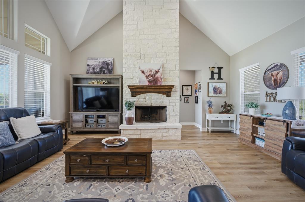 1065 Old Highway Howe, TX 75459 - Photo 14 of 39 Living room featuring a stone fireplace, light wood finished floors, and lofted ceiling