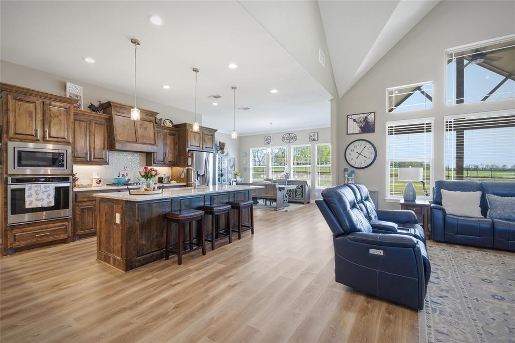 1065 Old Highway Howe, TX 75459 - Photo 39 of 39 Kitchen with open floor plan, a kitchen bar, stainless steel appliances, a kitchen island with sink, and light wood-style floors
