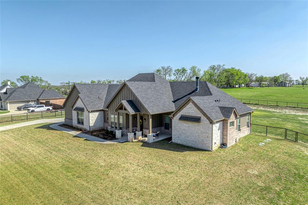 1065 Old Highway Howe, TX 75459 - Photo 3 of 39 View of front of property with stone siding, a fenced backyard, a shingled roof, covered porch, and board and batten siding