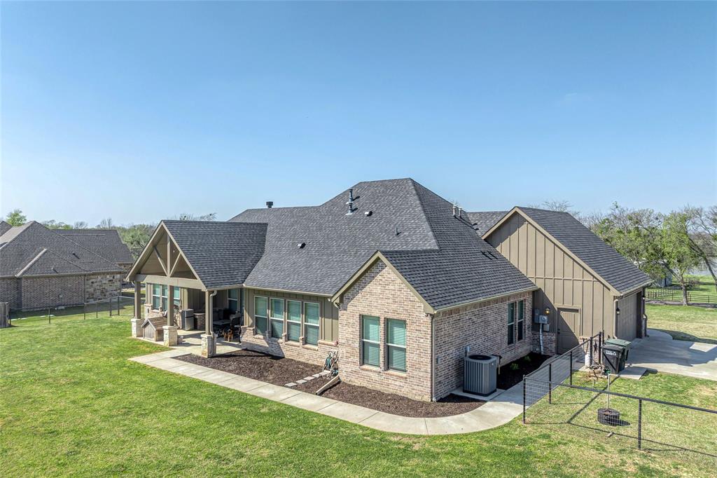 1065 Old Highway Howe, TX 75459 - Photo 4 of 39 Rear aerial view of house with a fenced backyard, board and batten siding, a patio, brick siding, and roof with shingles