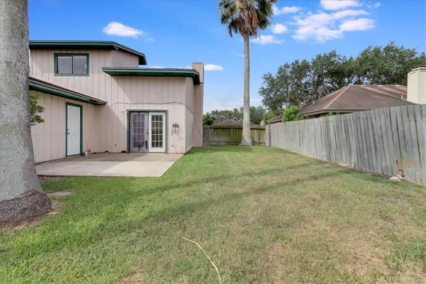 a view of a house with a yard and wooden fence