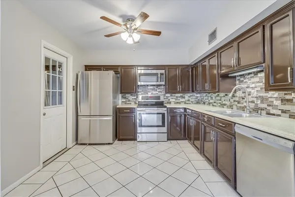 a kitchen with stainless steel appliances granite countertop a refrigerator sink and cabinets