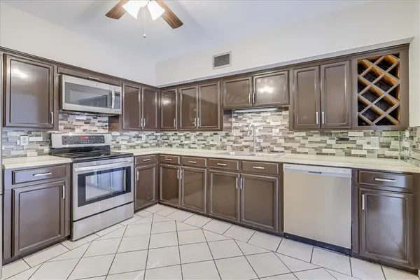 a kitchen with stainless steel appliances granite countertop a sink stove and cabinets