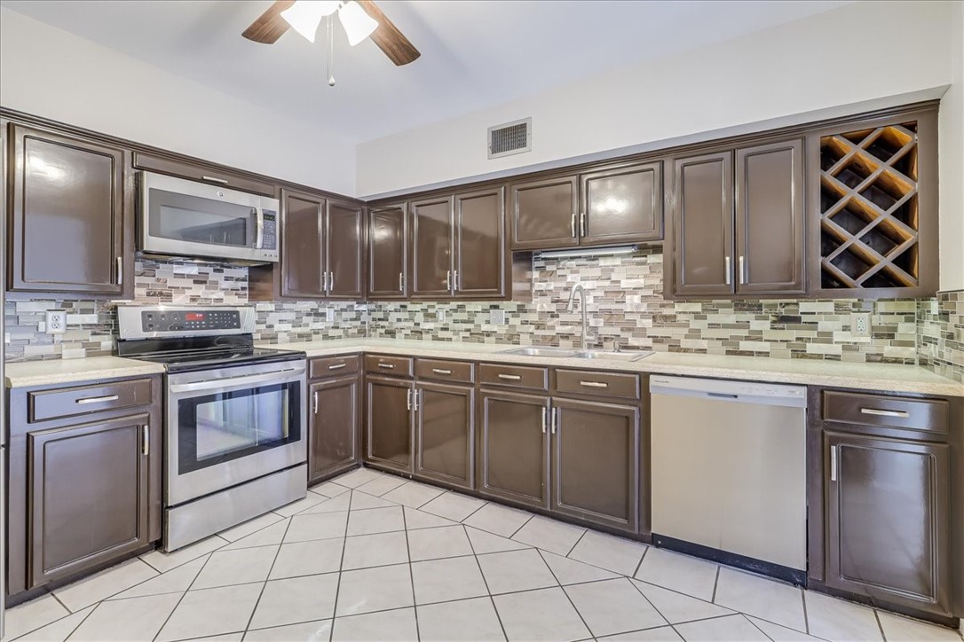 2938 River Crest Road Corpus Christi, TX 78415 - Photo 16 of 39 a kitchen with stainless steel appliances granite countertop a sink stove and cabinets