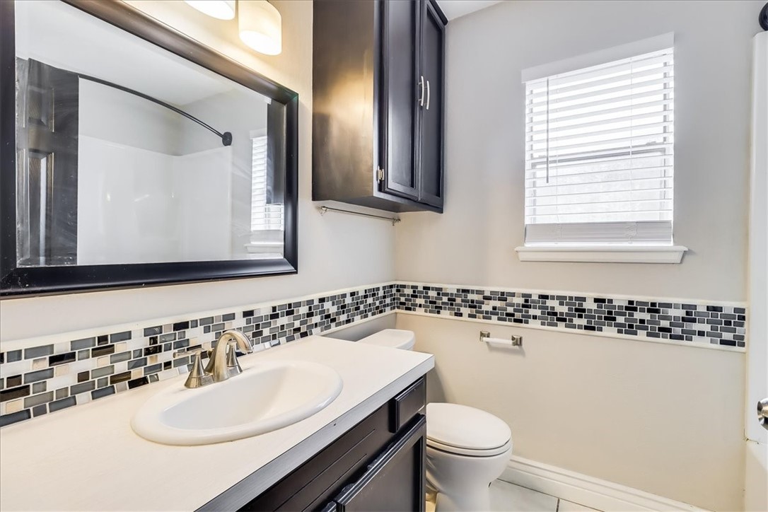 2938 River Crest Road Corpus Christi, TX 78415 - Photo 30 of 39 a bathroom with a sink a toilet and a mirror