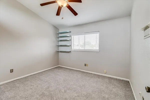 an empty room with closet and windows