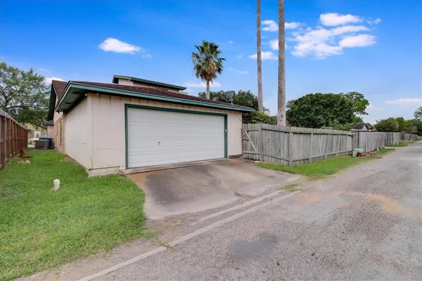 a view of a back yard with flower plants and wooden fence