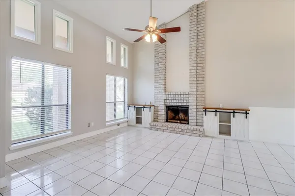 a view of an empty room with a fireplace and a window