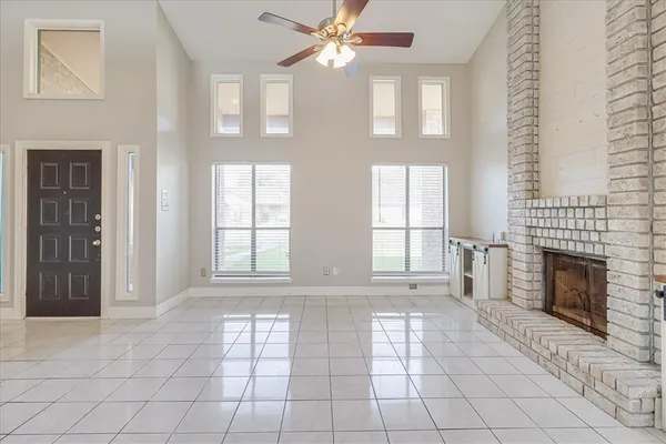 a view of an empty room with window and fireplace