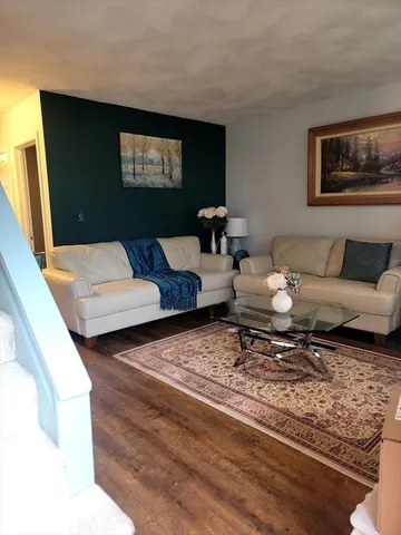 a living room with couches and painting on the wall