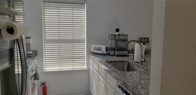 a kitchen with a granite countertop sink a stove and a window