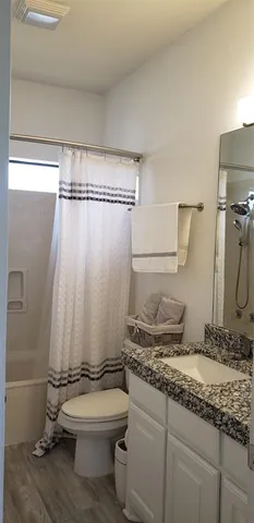 a bathroom with a granite countertop sink toilet and shower
