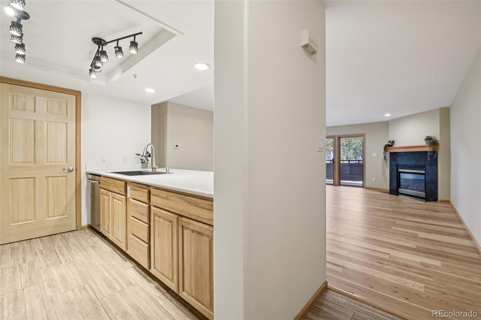 23674 Pondview Place, Unit B Golden, CO 80401 - Photo 6 of 35 a view of a kitchen from the hallway with a sink and wooden floor