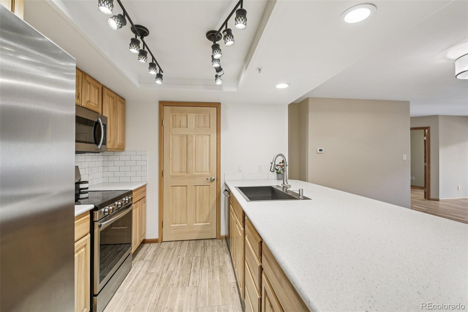 23674 Pondview Place, Unit B Golden, CO 80401 - Photo 8 of 35 a kitchen with a sink appliances and cabinets