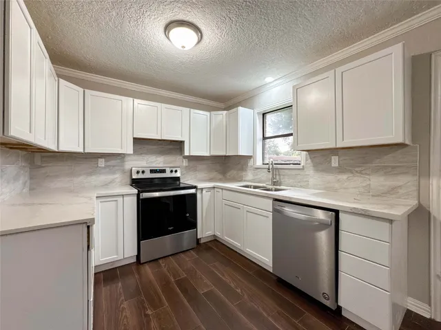 a kitchen with granite countertop white cabinets and white appliances
