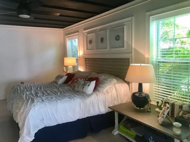 a bedroom with a bed a lamp and a window