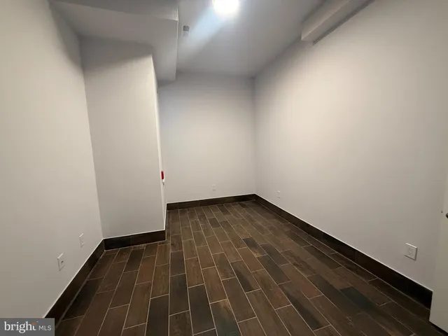 a view of a room with wooden floor and white walls