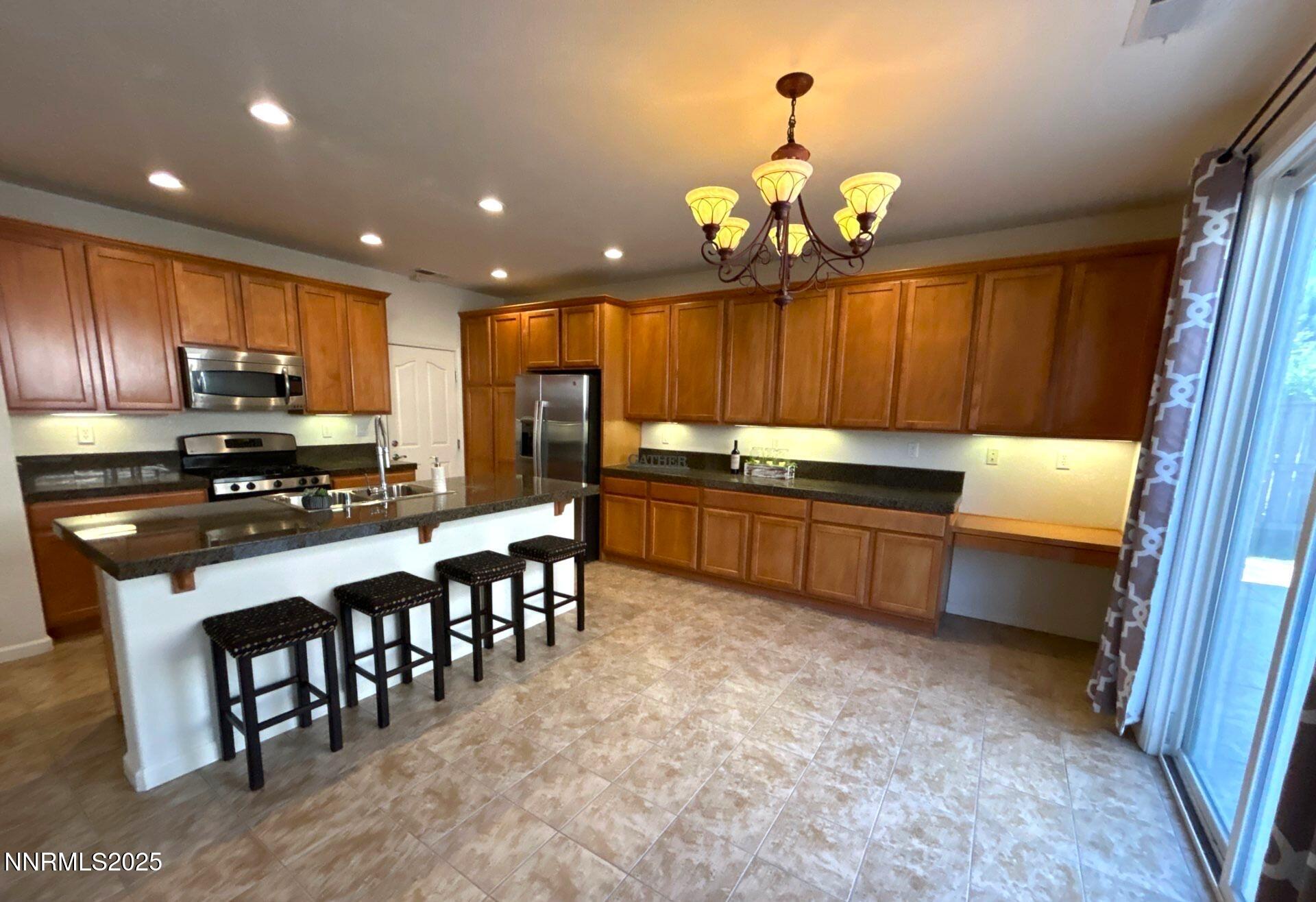 7150 Provence Circle Reno, NV 89523 - Photo 6 of 22 a kitchen with kitchen island granite countertop a sink counter top space appliances and cabinets